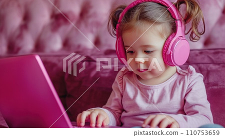 a pink and purple laptop is being used by a toddler next to a pair of headphones a pink and purple laptop is being used by a toddler next to a pair of headphones 110753659