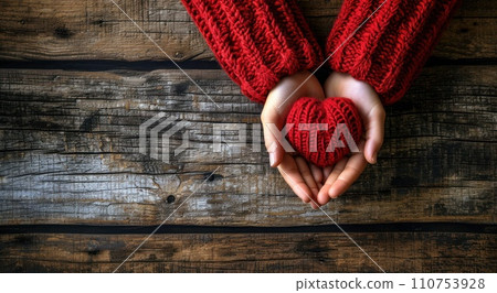 hands in red sweater and red heart on wooden background hands in red sweater and red heart on wooden background 110753928