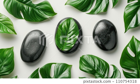 massage leaves and black stones on a white background 110754318