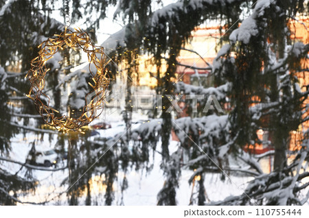 Christmas garland on the window, and snow covered fir trees Christmas garland on the window, and snow covered fir trees 110755444