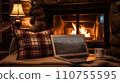 Laptop with a picture of a bonfire screen, indoor near burning fireplace in rustic style, with cozy blanket and cup of coffee. Seasonal remote work, internet, shopping. 110755595
