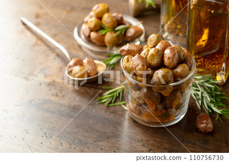 Spicy olives and bottles of olive oil on a wooden table. 110756730