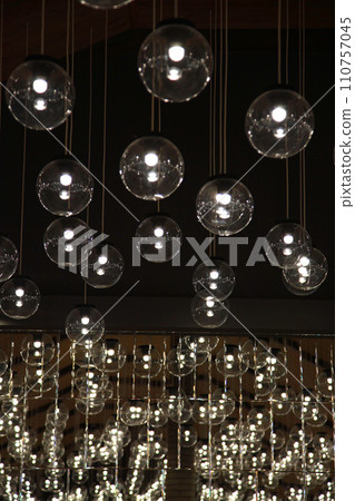 Round lamps hanging from ceiling in restaurant. Lamps decorated on the ceiling in restaurant. Celebrations in a restaurant. Original luxury decorative lighting in restaurant. Round lamps hanging from ceiling in restaurant. Lamps decorated on the ceiling in restaurant. Celebrations in a restaurant. Original luxury decorative lighting in restaurant. 110757045