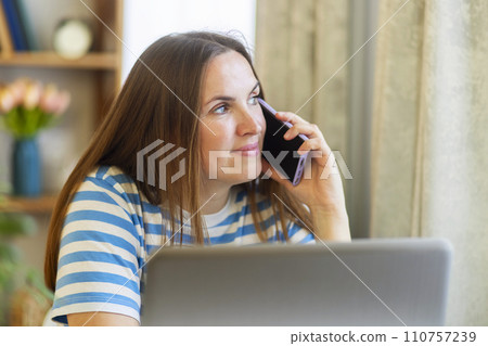 Woman Working from Home on a Phone Call Woman Working from Home on a Phone Call 110757239
