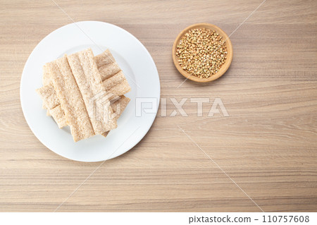Buckwheat crisp bread and buckwheat on plate on wooden background, gluten free. Dietary cookies 110757608