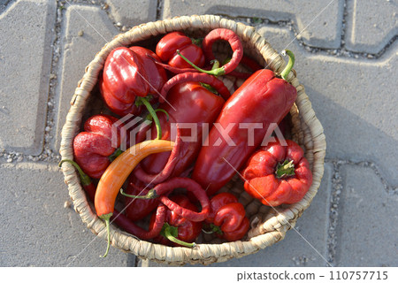 peppers in basket, on stone background 110757715