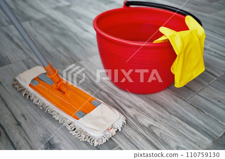 Mop, bucket of water, rubber gloves close-up. The concept of keeping your home clean and healthy. Mop, bucket of water, rubber gloves close-up. The concept of keeping your home clean and healthy. 110759130