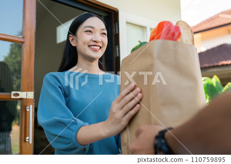 Asian young delivery man delivering package to female customer at home 110759895