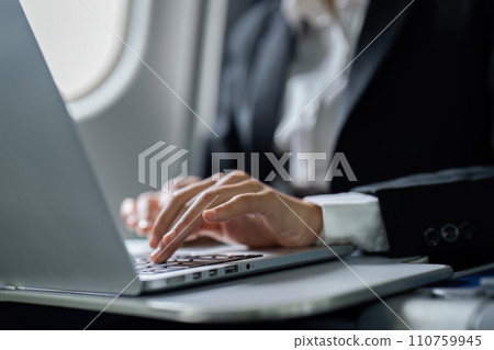 Beautiful Asian businesswoman working with laptop in aeroplane. working, travel, business concept Beautiful Asian businesswoman working with laptop in aeroplane. working, travel, business concept 110759945