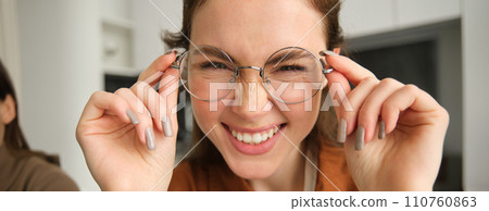 Close up portrait of attractive smiling woman with glasses, laughing and looking happy at camera 110760863