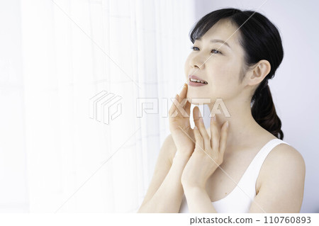 A woman in her 30s feels the moisture in her skin 110760893
