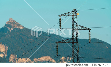 An electricity pylon and wires against the French Alps 110761426