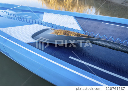 detail of stand up paddleboard with a paddle and safety leash detail of stand up paddleboard with a paddle and safety leash 110761587