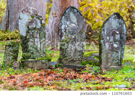 Stone statue and autumn leaves 110761603