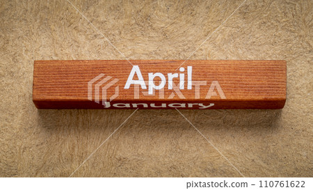 April and January text on wooden block against handmade bark paper in earth tones, calendar concept April and January text on wooden block against handmade bark paper in earth tones, calendar concept 110761622