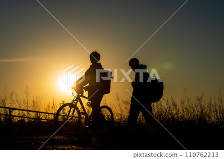 一個放學回來的男孩和日落 110762213