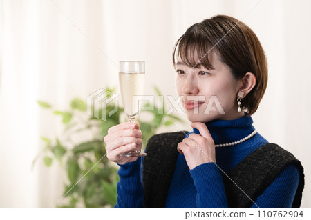 woman looking at champagne glass 110762904