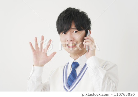 Surprised high school boy while calling on smartphone, white background, looking at camera Surprised high school boy while calling on smartphone, white background, looking at camera 110763050