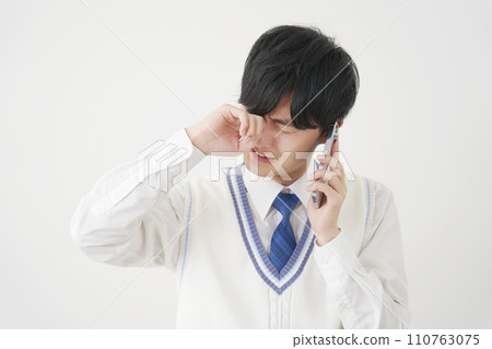 High school boy crying and calling on smartphone, white background High school boy crying and calling on smartphone, white background 110763075