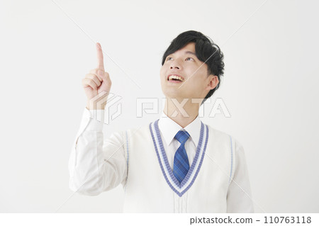 High school boy pointing upwards, white background 110763118