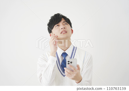 High school boy thinking while holding a smartphone, white background High school boy thinking while holding a smartphone, white background 110763139