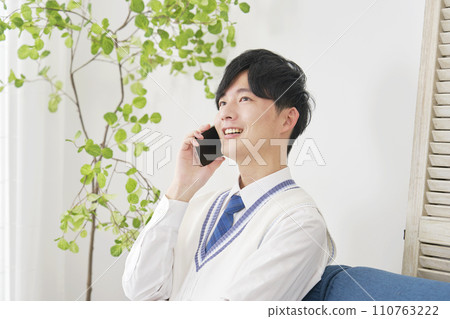 高中男孩在客廳打電話用智慧型手機 110763222