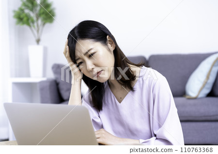 A woman in her 30s becomes unwell after working on a computer 110763368