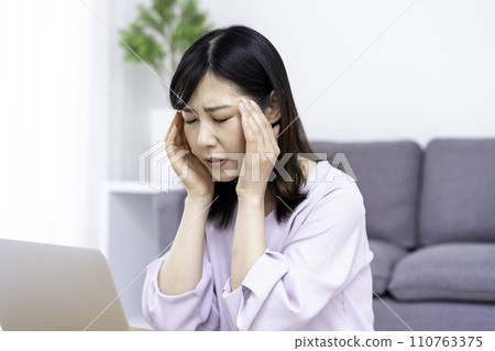 A woman in her 30s becomes unwell after working on a computer 110763375