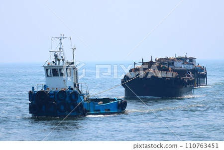 一艘小拖船拖著一艘駁船 110763451