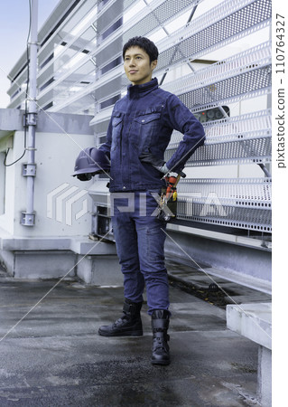 穿著牛仔工作服站在大樓屋頂上的年輕人的肖像攝影合作:有明教育藝術學院 穿著牛仔工作服站在大樓屋頂上的年輕人的肖像攝影合作:有明教育藝術學院 110764327