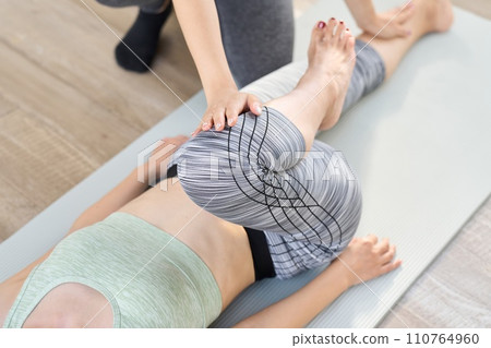 Woman doing partner stretch for lower body Woman doing partner stretch for lower body 110764960