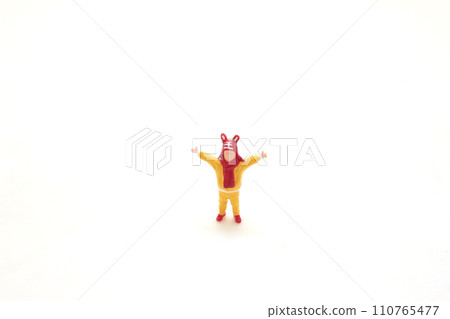a Toy Figure in Yellow with Red Hat on White Background a Toy Figure in Yellow with Red Hat on White Background 110765477