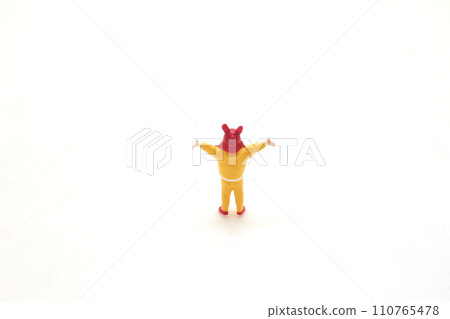 a Toy Figure in Yellow with Red Hat on White Background a Toy Figure in Yellow with Red Hat on White Background 110765478