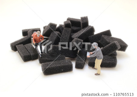 Miniature Workers with Foam Blocks on White Background 110765513