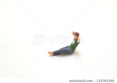 Miniature Man Relaxing with Hand on Head Isolated on White 110765540