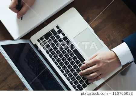 商人在電腦上工作時會做筆記的手 商人在電腦上工作時會做筆記的手 110766038