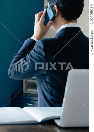 Businessman talking on smartphone in office 110766089