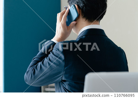 Businessman talking on smartphone in office Businessman talking on smartphone in office 110766095