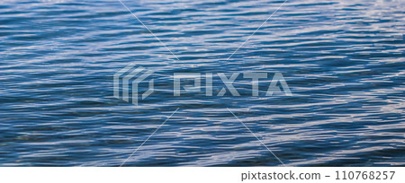 Blue sea in sunshine glow as surface background. Summer holidays and coastal nature concept Blue sea in sunshine glow as surface background. Summer holidays and coastal nature concept 110768257