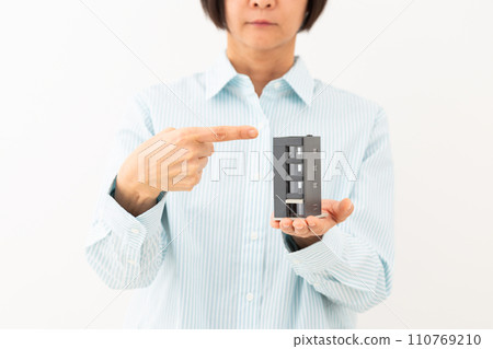 中年婦女指著一棟建築的房屋模型 110769210