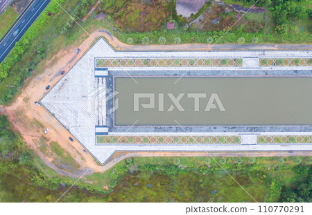 Aerial top view of arrow direction shape with garden park with green mangrove forest trees, river, pond or lake. Nature landscape background, Thailand. 110770291