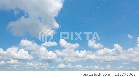 Clear blue sky with white fluffy clouds at noon. Day time. Abstract nature landscape background. Clear blue sky with white fluffy clouds at noon. Day time. Abstract nature landscape background. 110770305