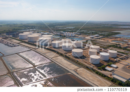 Aerial view of petrochemical oil refinery and sea in industrial engineering concept in Bangna district, Bangkok City, Thailand. Oil and gas tanks pipelines in industry. Modern metal factory. Aerial view of petrochemical oil refinery and sea in industrial engineering concept in Bangna district, Bangkok City, Thailand. Oil and gas tanks pipelines in industry. Modern metal factory. 110770319