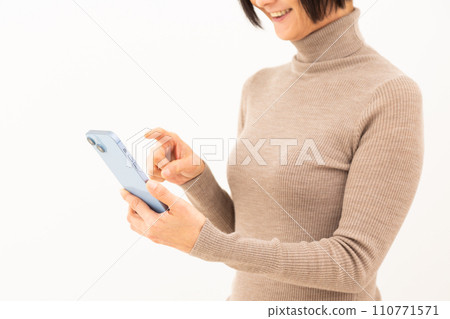 中年婦女微笑著操作智慧型手機 中年婦女微笑著操作智慧型手機 110771571