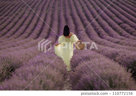 Woman lavender field. Lavender field happy woman in yellow dress in lavender field summer time. Aromatherapy concept, lavender oil, photo session in lavender Woman lavender field. Lavender field happy woman in yellow dress in lavender field summer time. Aromatherapy concept, lavender oil, photo session in lavender 110772156