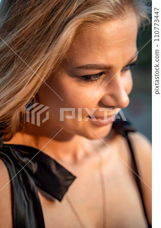 Blonde long hair, nature summer happy adult girl with long blond hair developing in the wind in nature. Dressed in a black top, white skirt. Blonde long hair, nature summer happy adult girl with long blond hair developing in the wind in nature. Dressed in a black top, white skirt. 110773447