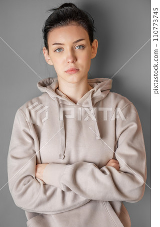 Pensive thoughtful young girl wearing sweatshirt with hood Pensive thoughtful young girl wearing sweatshirt with hood 110773745