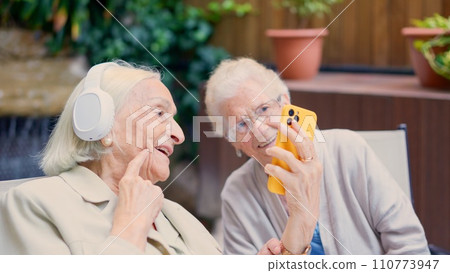 Seniors having fun with the mobile in a nursing home 110773947