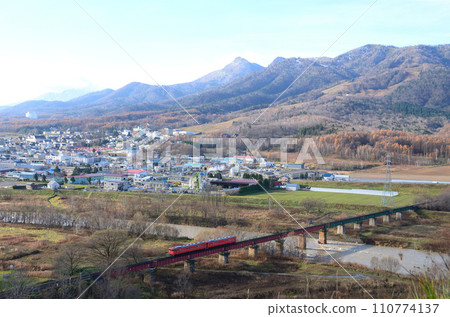 Two trains painted in metropolitan area colors crossing the Sorachi River 110774137