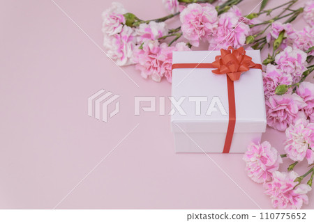 Mother's Day presents and carnations on pink background Mother's Day presents and carnations on pink background 110775652